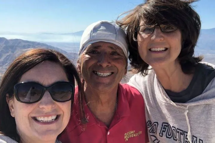 a close up of a man and a woman smiling and wearing sunglasses