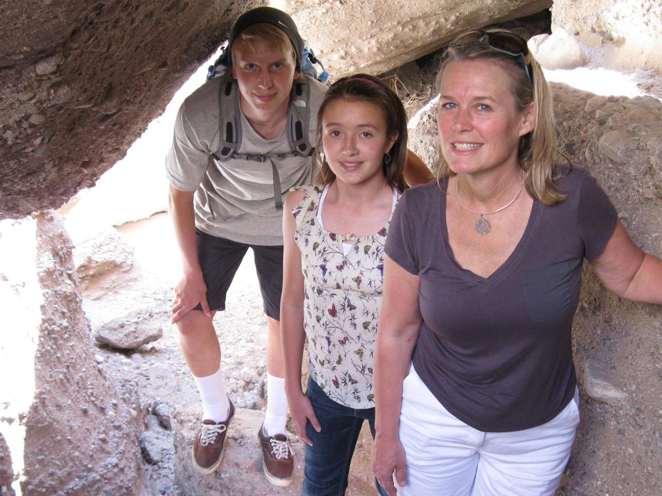 a man and a woman standing in front of a large rock