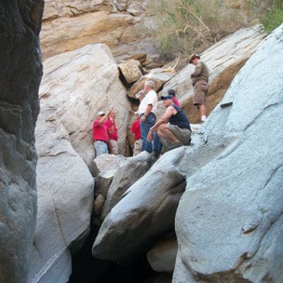 a group of people sitting on a rock