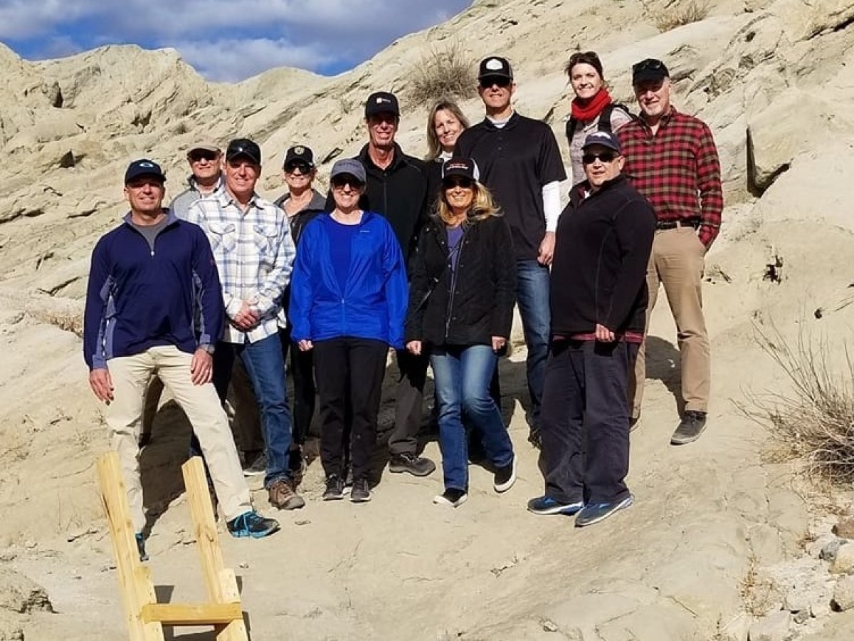a group of people standing in front of a mountain