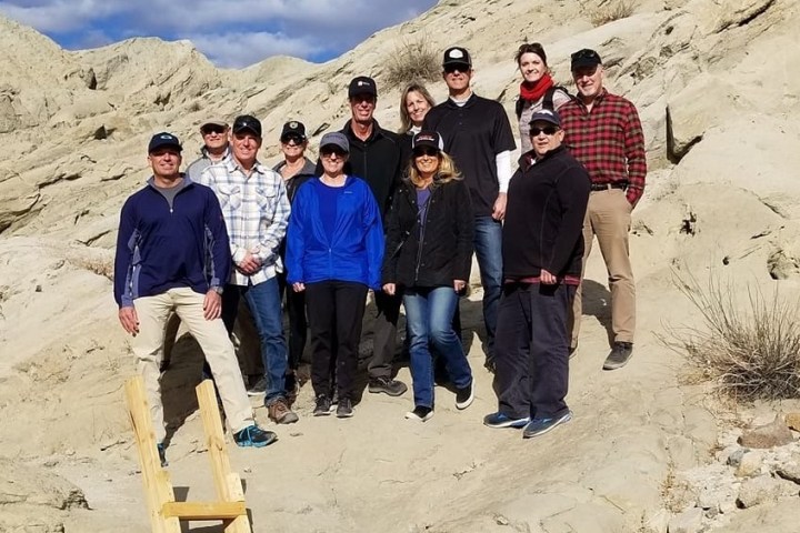 a group of people standing in front of a mountain