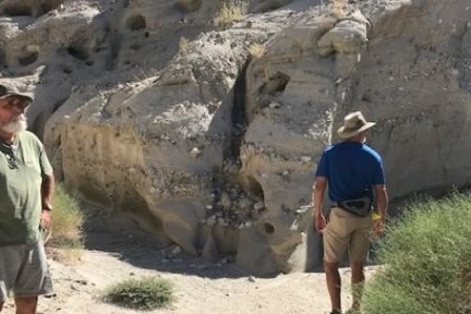 a man standing next to a rock