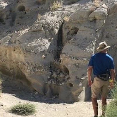 a man standing next to a rock